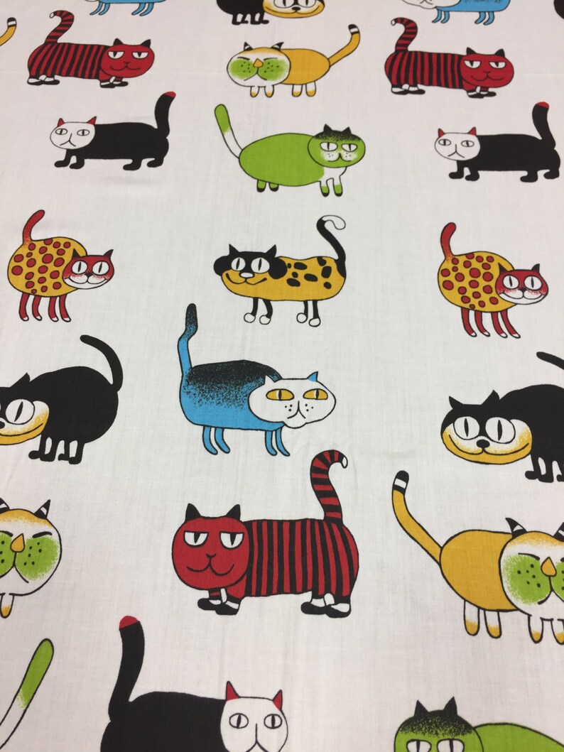 Puede incluir: Tela blanca con un patr&oacute;n repetido de gatos de dibujos animados coloridos. Los gatos est&aacute;n en varias poses y tienen diferentes expresiones faciales. Algunos gatos llevan manchas, rayas u otros patrones.