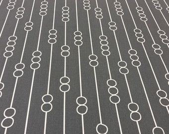 May include: A gray fabric with a white repeating pattern of circles connected by lines. The circles are arranged in a vertical line, with each line offset from the next.
