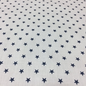 May include: White fabric with a repeating pattern of small navy blue stars.