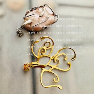 Pode incluir: Dois pingentes. O pingente superior apresenta uma pérola barroca rosa envolta em metal prateado. O pingente inferior é dourado e tem um design vazado estilizado. O nome da loja Etsy "etsy: lockedcrafts" é repetido na imagem.