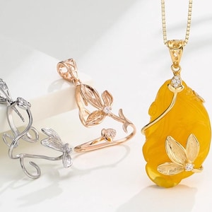 Peut inclure: Trois pendentifs à thème floral. L'un est argenté, le second est en or rose et le troisième est un pendentif en pierre jaune avec une chaîne en or. Chaque pendentif présente un motif floral avec de petits pierres précieuses claires.