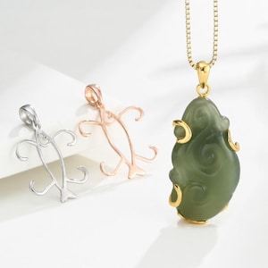 Peut inclure: Trois pendentifs : un pendentif argenté en forme de poisson, un pendentif en or rose en forme de poisson et un pendentif en jade vert avec des accents dorés sur une chaîne en or. Le pendentif en jade a une forme organique unique.