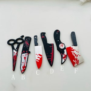 May include: Six black and red knives with a bloody design. The knives are labeled A through F.
