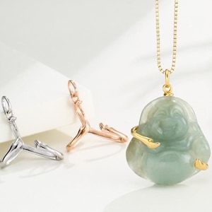 Peut inclure: Un pendentif Bouddha en jade vert clair suspendu à une chaîne en or, orné d'une étreinte en métal doré. Deux bélières métalliques supplémentaires sont présentées séparément, l'une argentée et l'autre en or rose, avec un design en forme de Y.