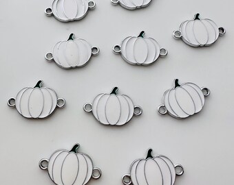 May include: Ten white metal pumpkin charms with green stems. Each charm has two silver jump rings for attaching to jewelry or other crafts.