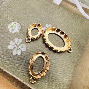 Peut inclure: Trois montures de lunette en métal doré de différentes formes ovales et rondes. Chaque lunette a un bord décoratif et une boucle pour l'attacher à d'autres composants. Les montures sont présentées sur un fond de style vintage.