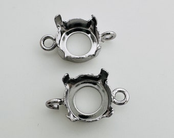 Könnte beinhalten: Zwei silberfarbene Metallfassungen zum Anbringen eines Edelsteins oder anderer Verzierungen. Jede Fassung hat eine runde Öffnung und eine Schlaufe zum Anbringen an einer Kette oder einem anderen Schmuckstück.