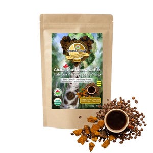 May include: A tan pouch of Annanda Chaga Mushroom Coffee, 230g, featuring a label with a birch tree and chaga mushroom graphic. The text reads Chaga Mushroom Coffee, Fine Grind, Medium Roast, Low Acid, and USDA Organic. Coffee beans and chaga chunks surround a cup of black coffee.