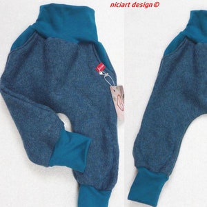 Könnte beinhalten: Babyhose in Türkisblau mit dunkelblauem Strickstoff und türkisblauen Bündchen. Die Hose hat eine lockere Passform und ist aus einem weichen, bequemen Material gefertigt.