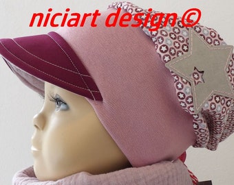 May include: A pink beanie with a burgundy visor and a brown star patch. The star patch has a smaller star cut out of the center. The beanie has a white and pink patterned fabric on the back.