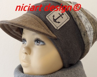 May include: A brown and gray knitted beanie with a brown fabric brim and a small leather patch with an anchor design. The beanie is worn by a child.