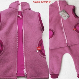 Könnte beinhalten: Ein rosa Fleece-Weste und passende Hose Set für ein Kind. Die Weste hat einen Reißverschluss und ein herzförmiges Detail auf der Vorderseite. Die Hose hat einen Reißverschluss und einen elastischen Bund.