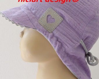 May include: A purple sun hat with a gray heart-shaped patch and a tie at the back. The hat is made of a soft, textured fabric.