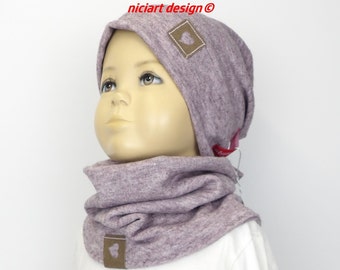 May include: A mauve knitted hat and matching neck warmer with a brown heart patch on each piece. The hat has a fold-over brim and the neck warmer is a cowl style.