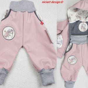 Könnte beinhalten: Zweiteiliges Baby-Outfit in Rosa mit grauen Akzenten. Das Outfit besteht aus einer Hose und einer Kapuzenjacke. Beide Teile haben eine Pferde-Grafik und graue Bündchen. Die Jacke hat einen Reißverschluss.