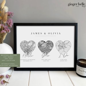 May include: A black and white print featuring three heart-shaped maps representing different locations. The text "JAMES & OLIVIA" is at the top of the print. The text "Hello" is below the first heart-shaped map, "Yes" is below the second heart-shaped map, and "I Do" is below the third heart-shaped map. Each heart-shaped map has a city name and date below it. The print is framed in a black frame.