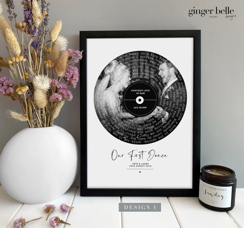 May include: Black and white photo of a couple dancing at their wedding, printed on a vinyl record with the song lyrics surrounding the photo. The text "Our First Dance" is below the record with the couple's names and wedding date.