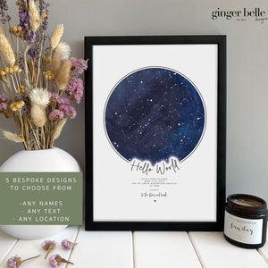 May include: A framed print with a dark blue star map and the words "Hello World." The print has custom text and a black frame. The image also shows a white vase with dried flowers and a scented candle.