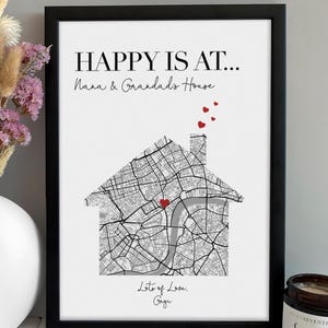 May include: A framed print featuring the text HAPPY IS AT... Nana & Grandad's House, with a black and white street map shaped like a house. A red heart marks a location on the map, and three small red hearts float above the chimney. The text Lots of Love. Gage is at the bottom.