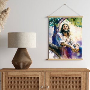 May include: A digital print of a watercolor painting depicting a man with long hair and a beard sitting on a tree branch. He is smiling and looking up at the sky. The painting is done in shades of blue, purple, and green.