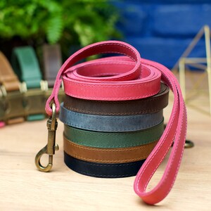 Puede incluir: Una pila de seis correas de cuero para perros en varios colores, incluyendo rosa, marr&oacute;n, azul, verde, marr&oacute;n y negro. Las correas est&aacute;n enrolladas y apiladas una encima de la otra. Las correas son todas de cuero y tienen un borde cosido.