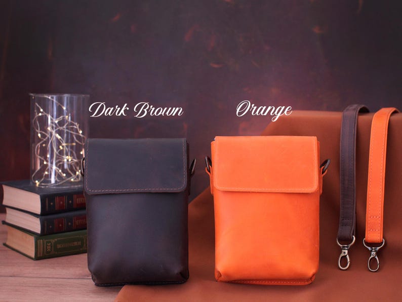 May include: Two leather crossbody bags, one dark brown and one orange, with matching straps. The dark brown bag is on the left, and the orange bag is on the right. The text "Dark Brown" and "Orange" are above the bags.