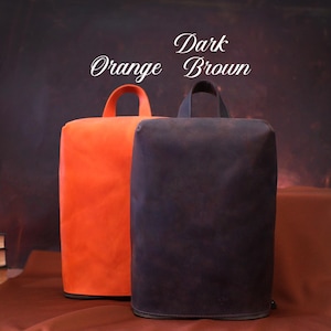 May include: Two rectangular, upright bags with top handles. One is bright orange, the other is dark brown. The bags have a zipper at the base. The text "Orange" and "Dark Brown" is written above the bags.