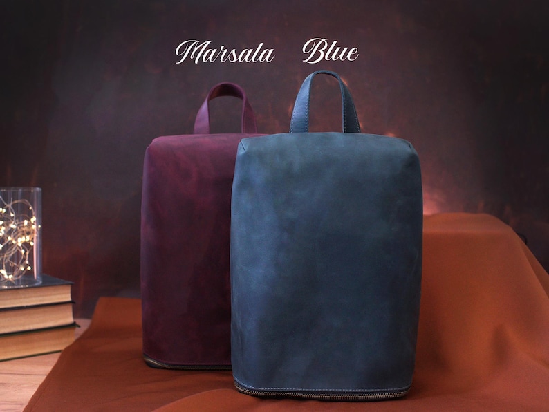 May include: Two rectangular bags, one in a deep burgundy and the other in a muted blue, each with a top handle and a zipper closure. The text "Marsala" and "Blue" are above the bags.