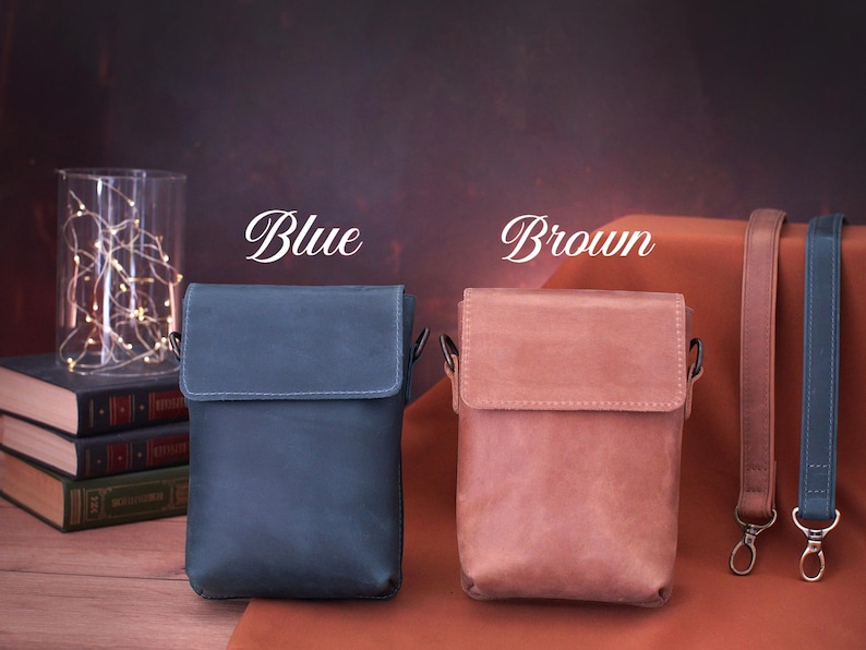 May include: Two leather crossbody bags, one blue and one brown, with matching straps. The bags have a rectangular shape with a flap closure. The word "Blue" and "Brown" are written above each bag.
