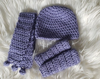 May include: A set of purple crocheted baby accessories including a hat, mittens, and a headband.