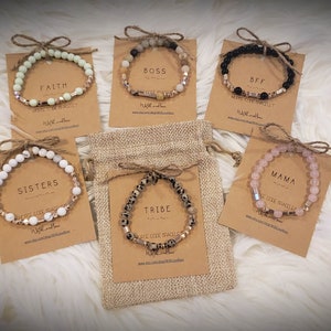 May include: A set of ten beaded bracelets with different colored stones and metal accents. Each bracelet has a different word on it, including "Faith", "Boss", "BFF", "Sisters", "Tribe", and "Mama".