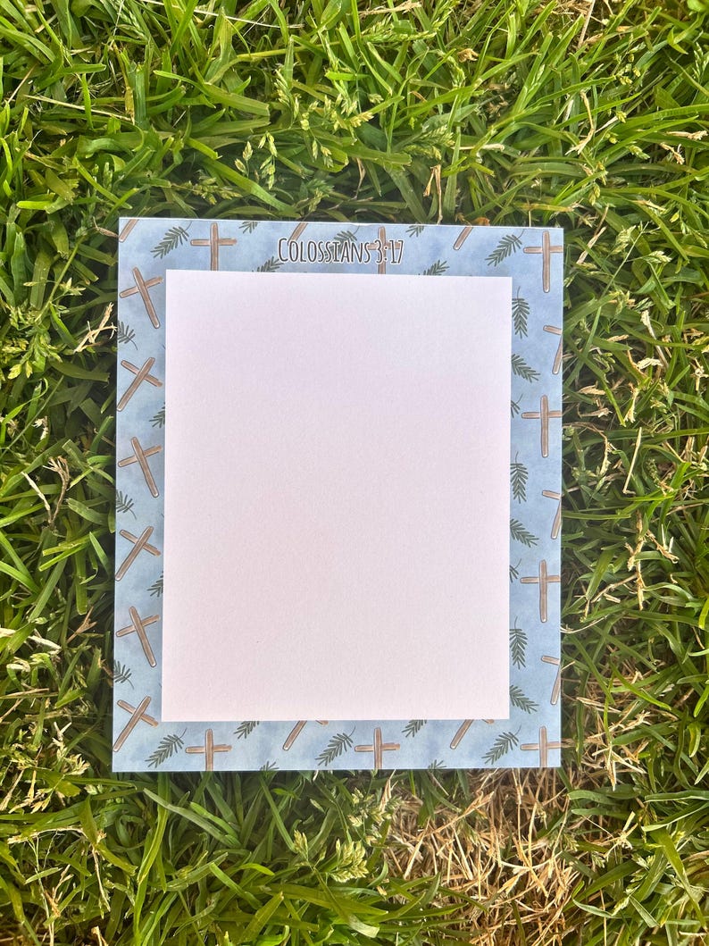 May include: A blue and white notepad with a border of brown crosses and green leaves. The text "Colossians 3:17" is printed at the top of the notepad.