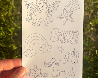 May include: A sheet of black and white coloring pages featuring unicorns, rainbows, stars, and the word "Sparkle". The sheet also includes the text "I love unicorns".