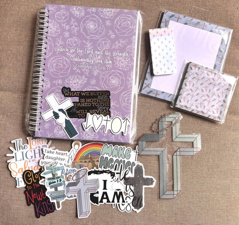 May include: A collection of religious-themed stickers and a purple spiral notebook with a floral design and the text "Search for the Lord and His strength; continually seek Him 1 Chronicles 16:11".