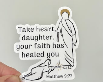 May include: A white sticker with a black outline illustration of a figure with a halo, and another figure kneeling. The sticker has the text "Take heart, daughter, your faith has healed you" and "Matthew 9:22".