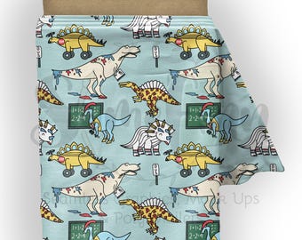 May include: A light blue fabric featuring a repeating pattern of cartoon dinosaurs, including yellow dinosaurs on wheels with stop signs, white dinosaurs with paint splatters, and blue dinosaurs standing next to green chalkboards with math equations.