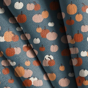 May include: A seamless pattern featuring various shades of orange, pink, and white pumpkins on a blue background. The pumpkins are arranged in a repeating pattern, creating a festive and autumnal design.