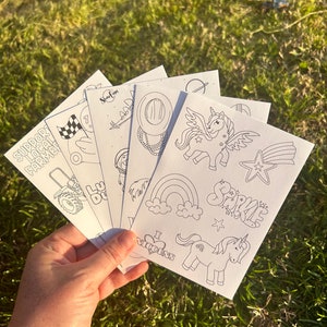 Pode incluir: Um conjunto de seis páginas para colorir em preto e branco com vários desenhos, incluindo um trator, um arco-íris, um unicórnio e um chapéu de cowboy. As páginas são impressas em cartolina branca e estão prontas para serem coloridas.