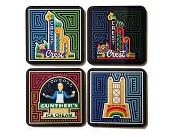May include: Set of four square coasters with colorful geometric designs. Two coasters feature a stylized building with the text "Crest" and the other two coasters feature a stylized ice cream cone with the text "Gunther's Ice Cream".