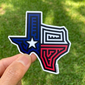 May include: A sticker of the state of Texas in the shape of the state outline. The sticker is designed with a geometric pattern in the colors of the Texas flag: blue, white, and red. The sticker has the text "PAPERnCLAS" at the bottom.
