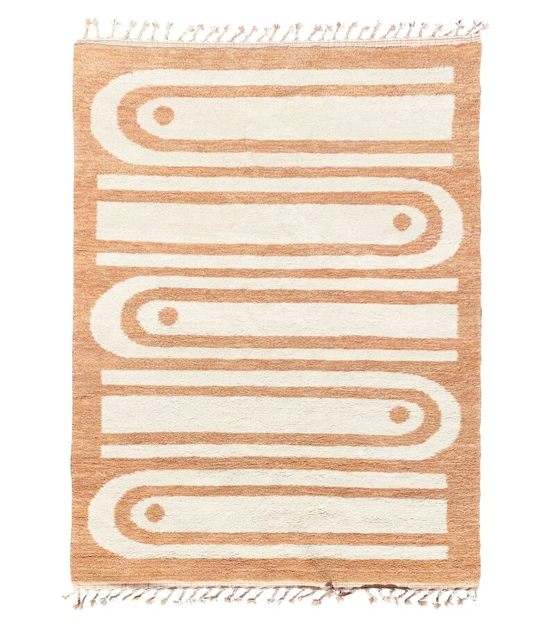 May include: A tan and white geometric rug with a repeating pattern of rounded arches and circles. The rug has a fringe border.