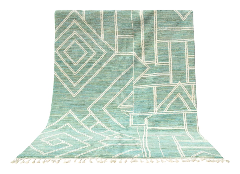May include: A teal and white geometric patterned rug with fringe on the edges.