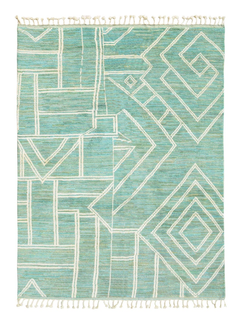 May include: A teal blue rug with a white geometric pattern. The rug has a fringe border.