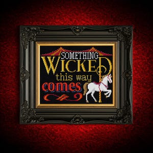 Puede incluir: Arte de punto de cruz en un marco negro adornado. La obra presenta el texto "SOMETHING WICKED this way COMES" con un caballo blanco. El fondo es negro con un borde dorado.