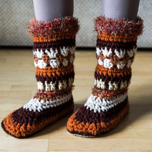 May include: Crocheted brown, orange and white striped slipper socks with a fluffy trim.