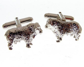 May include: A pair of silver-toned metal cufflinks, each featuring a three-dimensional sculpted figure of a muskox. The muskoxen have a textured, shaggy appearance and are attached to standard swivel-style toggle backings for shirt cuffs.