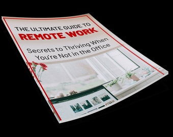 Könnte beinhalten: Ein weißes Heft mit rotem Rand und dem Text "THE ULTIMATE GUIDE TO REMOTE WORK Secrets to Thriving When You're Not in the Office". Das Heft ist schräg gestellt und im Hintergrund ist ein Fenster mit Pflanzen und einem Computerbildschirm zu sehen.