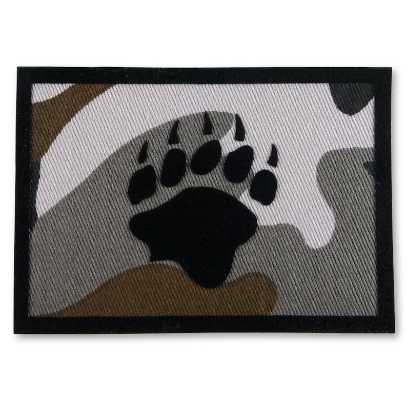 May include: A black bear paw print on a camouflage background. The patch is surrounded by a black border.
