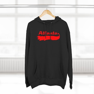 May include: Black hooded sweatshirt with a red outline of the state of Georgia and the word "Atlanta" in red lettering.