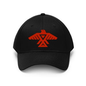 May include: A black baseball cap with a red embroidered Native American eagle design.